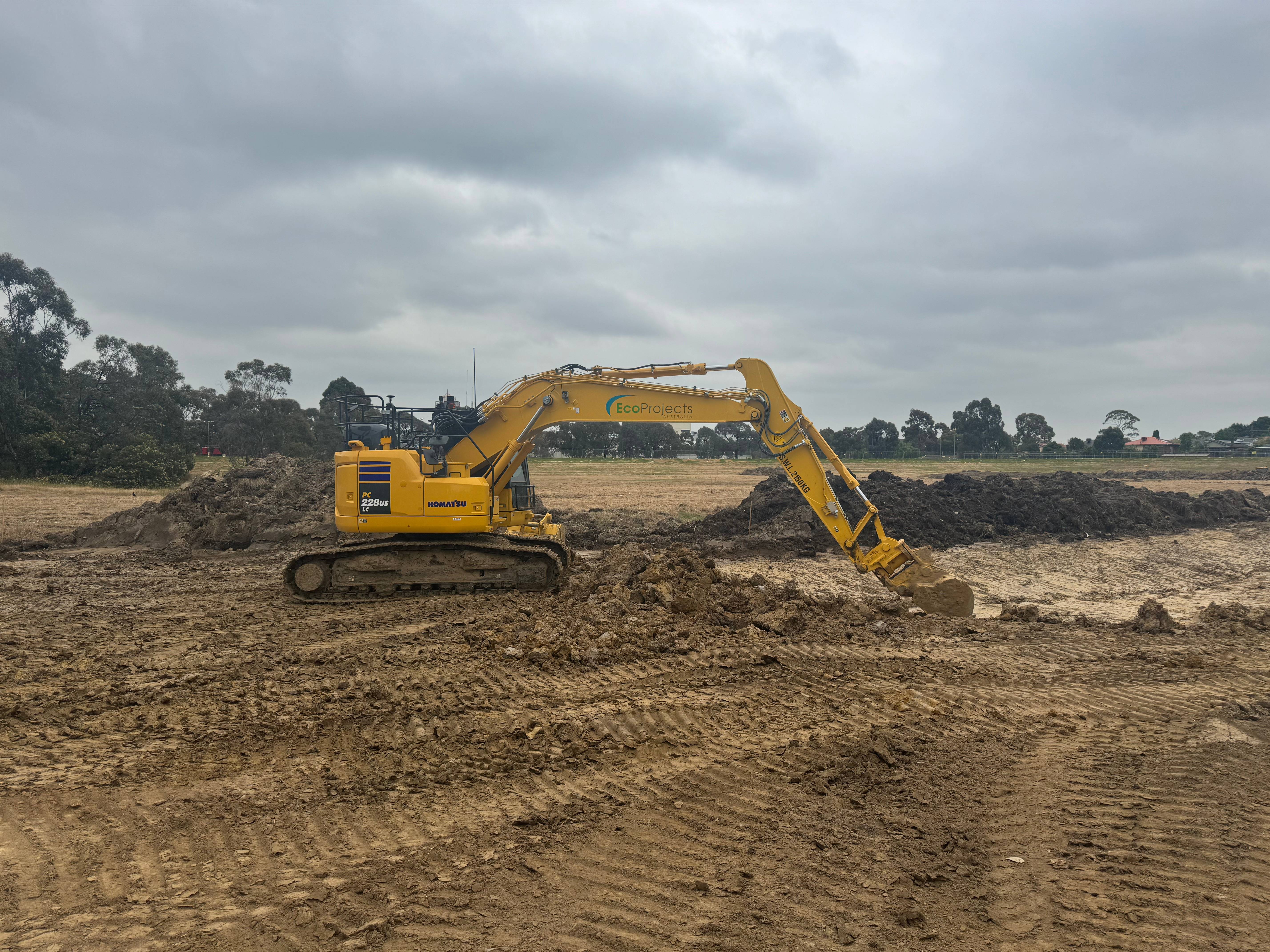 Yellow Komatsu earthmoving machine digging dirt