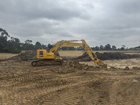 Yellow Komatsu earthmoving machine digging dirt