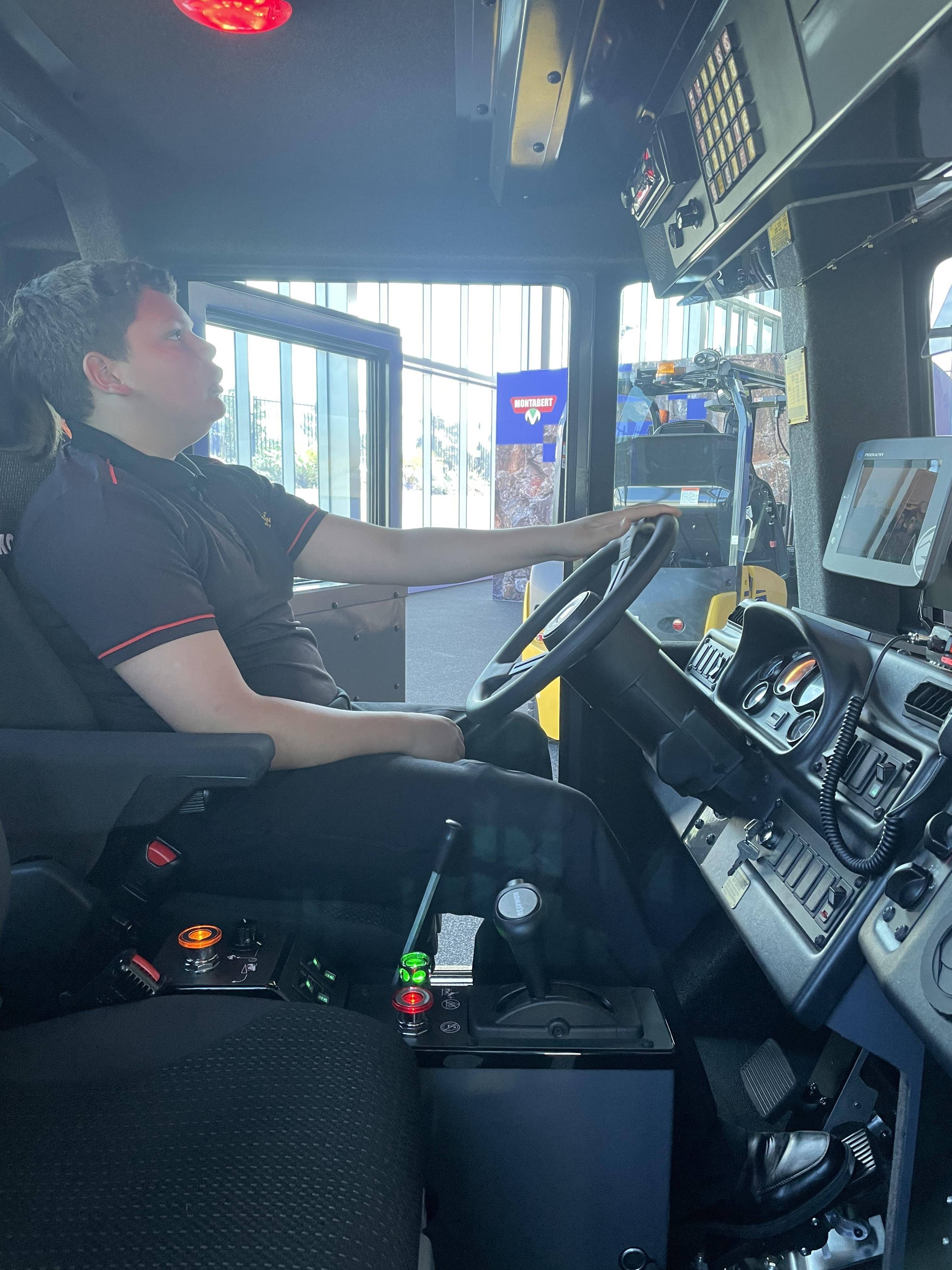 Boy inside sitting inside machine cab