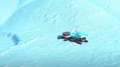 A Komatsu machine on a textured blue surface, evoking a futuristic or icy landscape.