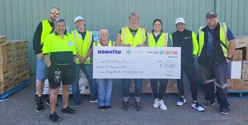 Group of people standing together with large cheque prop