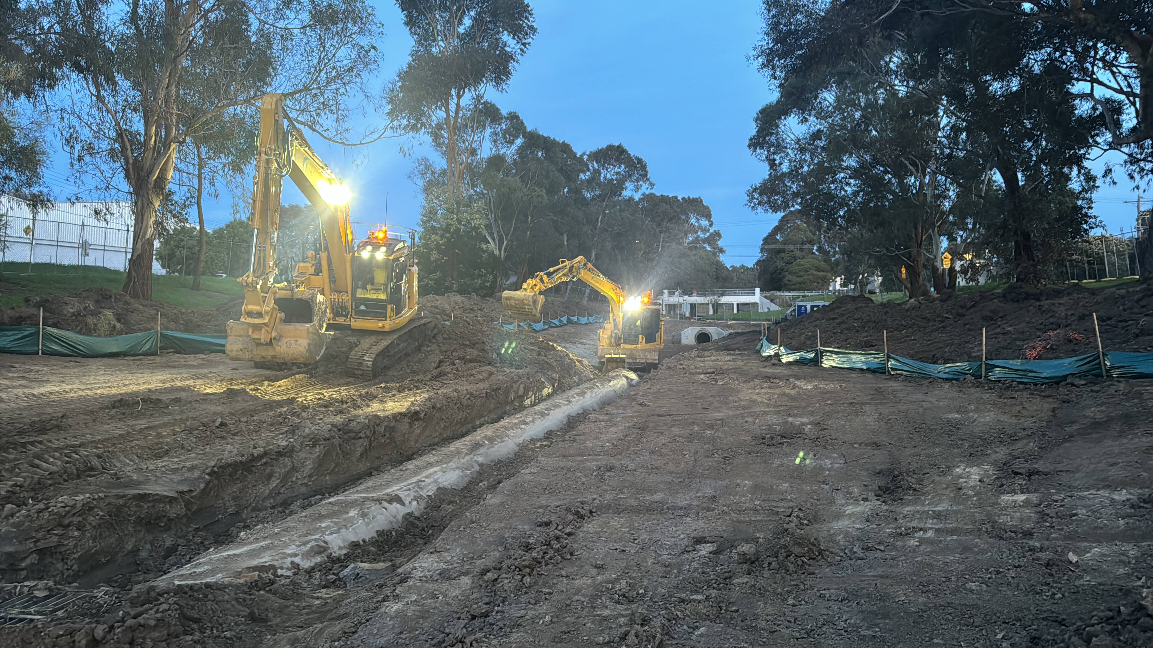 Two yellow Komatsu earthmoving machines working