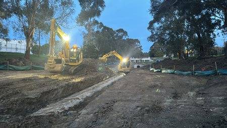Two yellow Komatsu earthmoving machines working