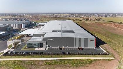 Aerial view of a large fulfilment center with extensive parking space, located in a suburban area.