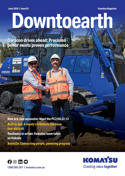 Cover of Komatsu Magazine's June 2025, Issue 81, featuring two workers in high visibility gear standing beside a new Komatsu excavator, under the headline 'Down to Earth - Power drives ahead: Precision.' Additional text discusses the features of the PC220LCi-12 excavator and Komatsu's sustainability initiatives.
